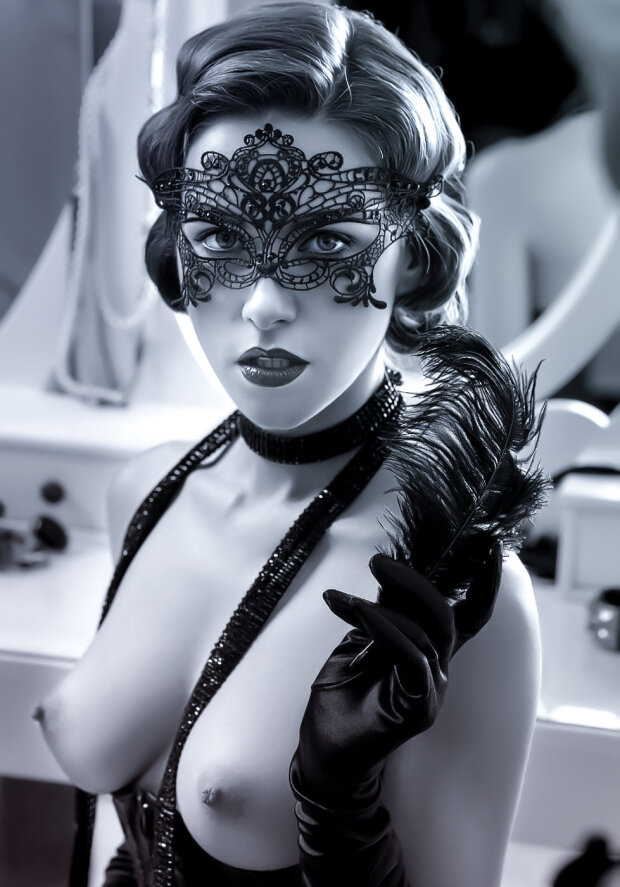 Beautiful woman in masquerade mask showing off her perfect chest